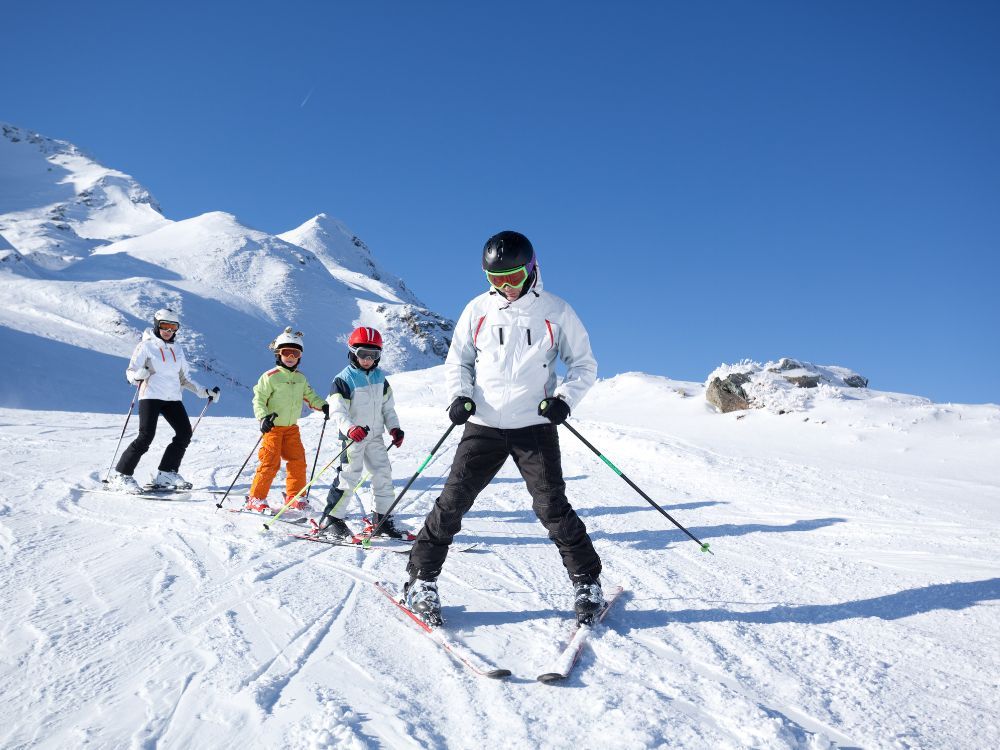 Familie met 2 kinderen skiet in de Alpen